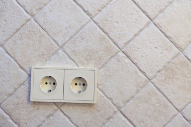 Düz kenarlı güzel bej fayanslar çapraz olarak serilmiştir. Geçmişi. Sol altta çift priz var.