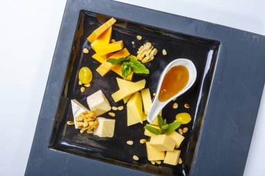 Peynir tabağı. Fındık ve ballı peynirin farklı türleri. Beyaz arka planda. Yukarıdan görünüşü