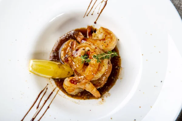 Fried tiger prawn tails with teriyaki sauce with a slice of lemon. Close up. The view from the top Stock Image