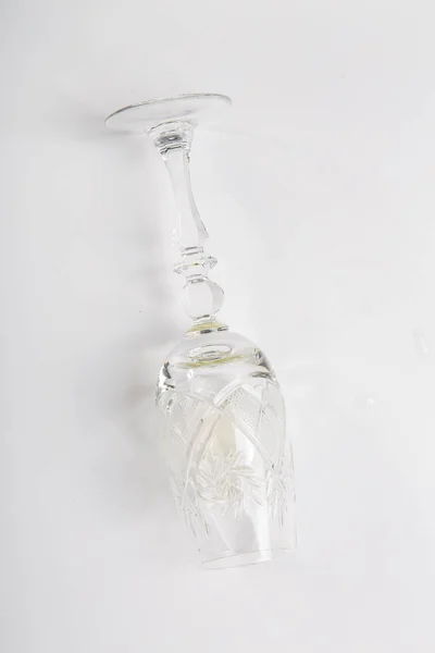 Un bicchiere di vino bianco giace sul suo lato su uno sfondo bianco — Foto Stock