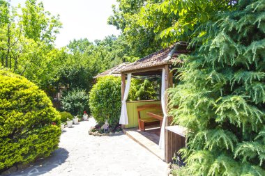 Baharda bir yaz kafesinde ahşap çardaklar. Çevrede bahar yeşilliği ve ağaçlar