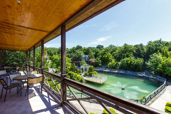 Veranda del restaurante con vistas al lago de truchas con una fuente — Foto de Stock
