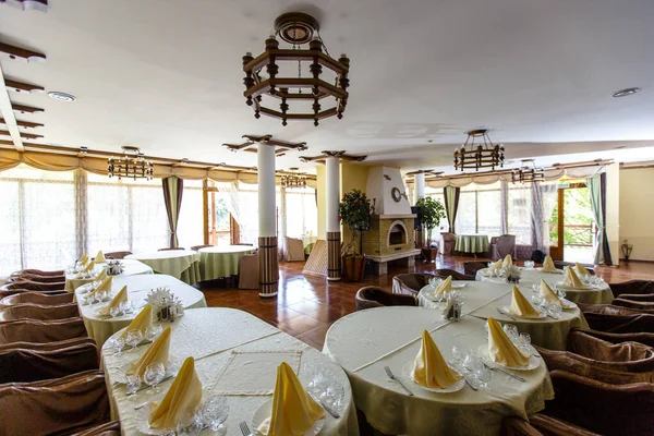 Large restaurant Hall with columns and fireplace. Canned tables. Greek style