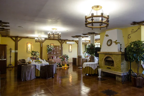 Large restaurant Hall with columns and fireplace. Canned tables. Greek style