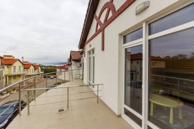 Kulübenin ikinci katında, yerleşim köyü manzaralı bir balkon.