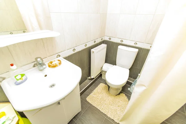 Ванная комната в гостевом доме в белой черепице с туалетом и раковиной — стоковое фото