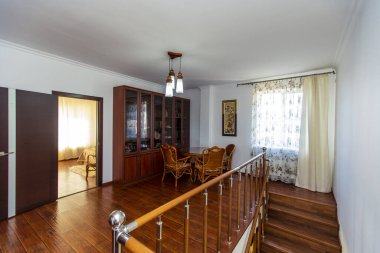 Kütüphane evin ikinci katında, ahşap bir merdivenin çıktığı yerde. Kitaplarla dolu büyük bir kitaplık. Hasır masa ve dört sandalye. Yatak odalarına iki kapı.