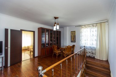 Kütüphane evin ikinci katında, ahşap bir merdivenin çıktığı yerde. Kitaplarla dolu büyük bir kitaplık. Hasır masa ve dört sandalye. Yatak odalarına iki kapı.