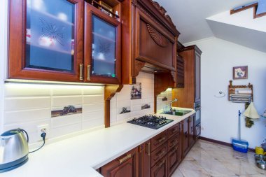 Maun ağacından yapılmış antik ahşap mutfak seti. Mobilyalar ahşap oymalarla kaplı. Gaz sobası, kaput, bulaşık.