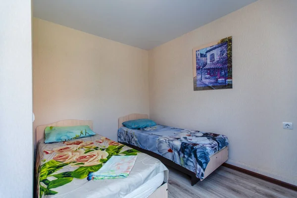 Una pequeña habitación en la casa de huéspedes con dos camas individuales con una cama verde y azul.. —  Fotos de Stock