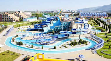 Güneşli bir sabahta sahilde su parkı. Sarmal borular şeklinde ve büyük şişirilebilir bir daire şeklinde iniyor.. 