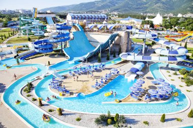 Güneşli bir sabahta sahilde su parkı. Sarmal borular şeklinde ve büyük şişirilebilir bir daire şeklinde iniyor.. 