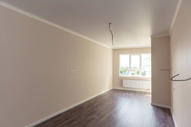 Yeni bir binada, yenilenmiş bir oda. Duvarlar yeşil ve pembe, zemin 