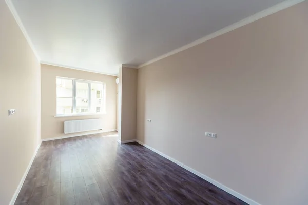 Una stanza vuota con pareti bianche e pavimenti in legno. Nuova ristrutturazione fresca. La porta del corridoio . — Foto Stock