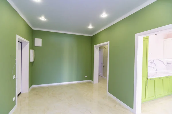 Corridoio vuoto con pareti verdi e pavimento in marmo in un nuovo appartamento con una nuova ristrutturazione. Le porte conducono dalla sala a diverse stanze . — Foto Stock