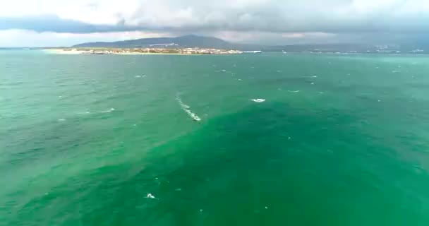 Windsurfer in Neoprenanzügen rasen bei herbstlich stürmischem Wetter im Badeort Gelendschik am Schwarzen Meer unter Segel. Video von einer Drohne — Stockvideo