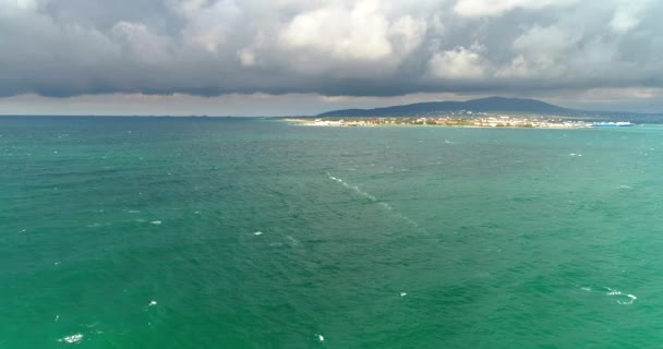 Windsurfaři ve wetsuits závod pod plachtou v podzimním bouřlivém počasí v letovisku Gelendzhik, Černé moře. Video z dronu — Stock video