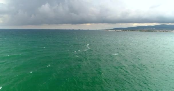 Tempesta d'autunno mare, nuvole, vento. Windsurfisti nuotare in lontananza. Tratto da un quadrocopter — Video Stock