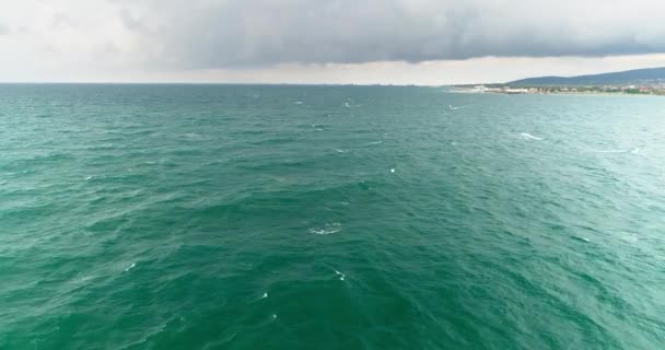 Sonbahar fırtınası denizi, bulutlar, rüzgar. Rüzgar sörfçüleri uzaklarda süzülüyor — Stok video