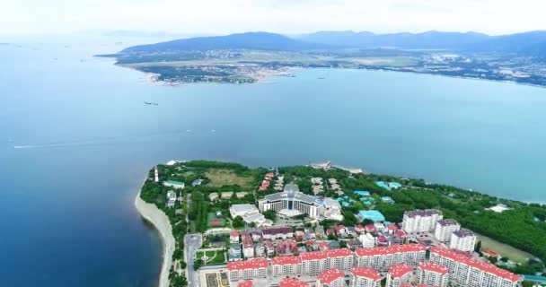 The Resort of Gelendzhik. Kvadkoptern går ner över ingången till bukten. Du kan se en tjock och tunn udde, Gelendzhik fyr, ett nytt kvarter av hus i förgrunden — Stockvideo