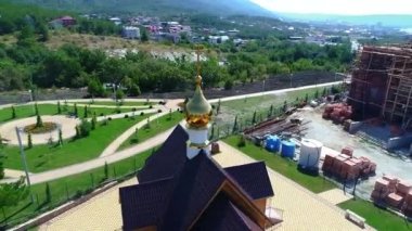 Akşam karanlığında küçük bir Ortodoks Kilisesi 'nin yaldızlı kubbesinin etrafında uç. Arkaplanda dağlar