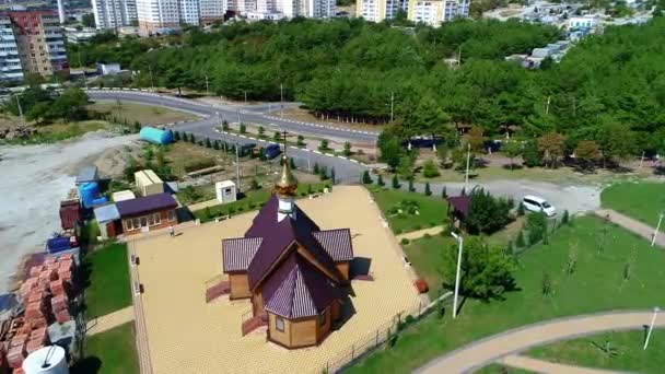 Fliegen Sie an einem sonnigen Tag um eine kleine orthodoxe Holzkirche am Eingang zur Stadt Gelendschik — Stockvideo