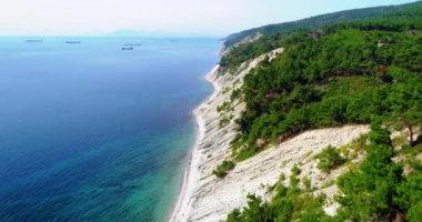 Gelendzhik 'ten Novorossiysk' e Karadeniz kıyısından uçuş. İnsansız hava aracı yüksek eğimli kaya tabakalarının üzerinde uçar. Dağlar çam ağaçlarıyla kaplı. Küçük bir çakıl taşı plajı