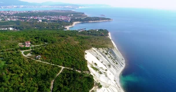 Flight over the sea coast near Gelendzhik. At the bottom of the high precipitous rocks, the Black sea. Clear Sunny weather. We fly towards Gelendzhik, which is visible on the horizon. Under the drone — Stock Video