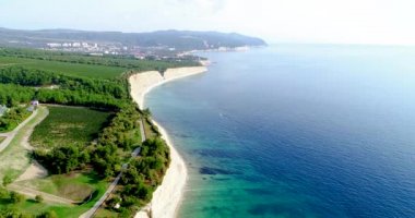 Büyük beyaz kayalarla Karadeniz kıyısında uçuyorlar. Üzüm bağları ve orman kıyısında. Arka planda Divnomorskoe tatil köyü var. Deniz berrak ve pürüzsüz - sakin. Büyük bir gövde