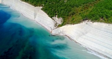 Gelendzhik tatil köyü. Yüksek sarp kayalıkları olan kıyı şeridi ormanla kaplı ve altında çakıl taşı plajı var. Bir vadi ve ahşap bir merdivenle denize ineceğiz. 