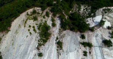 Güneşli bir havada küçük bir çakıl taşı plajı olan beyaz uçurumlar boyunca uçuyorlar. Çam ağaçları kayalarda yetişir. Kayaların katmanlı bir yapısı var. Deniz berrak ve pürüzsüz