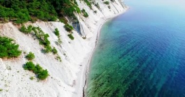 Gelendzhik 'ten Novorossiysk' e Karadeniz kıyısından uçuş. İnsansız uçak yüksek eğimli kayaların üzerinden uçuyor. Dağlar çam ağaçlarıyla kaplı. Dağ evinde. Uzaktaki gemiler