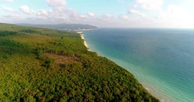 Büyük beyaz kayalarla Karadeniz kıyısında uçuyorlar. Kayaların dibinde küçük bir çakıl taşı plajı var. Ormanın kıyısında. Arka planda Divnomorskoe tatil köyü var. Deniz...