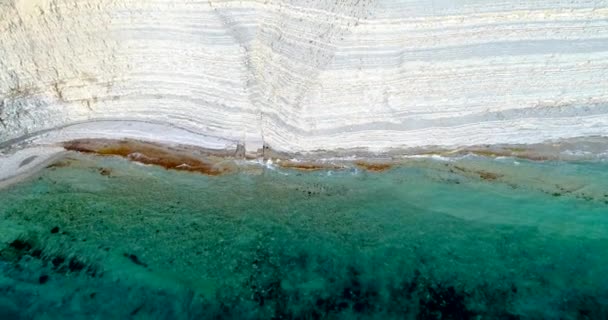 Dzika plaża pod wysoką białą skałą w rejonie Gelendzhik. Kemping Sosnovka. Przezroczysta woda, skały warstwowe, plaża żwirowa, wodorosty morskie — Wideo stockowe