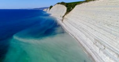 Divnomorsk 'tan kıyı boyunca Gelendzhik şehrine doğru sürerken Karadeniz kıyısındaki kayalar ve çakıllı vahşi plajlar. Sahildeki beyaz katmanlı kayaların üzerinde uçuyor. Yukarıdan, kayalar