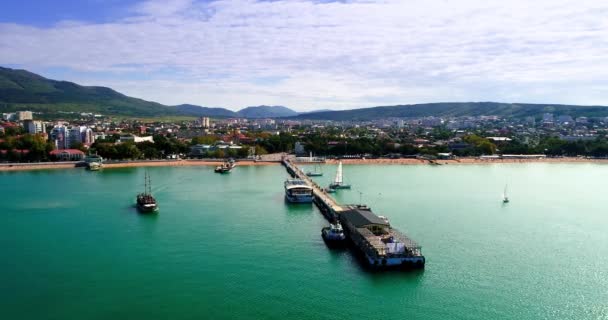 El dron vuela a la parte central del complejo de Gelendzhik - el muelle de mar, la plaza cerca del ayuntamiento, el terraplén y la playa central de arena. Un gran cuerpo de agua — Vídeos de Stock