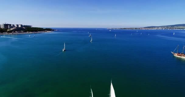 Vários belos iates brancos sob vela e um navio de madeira partem do cais central do resort de Gelendzhik e vão para a saída da Baía de Gelendzhik em mar aberto. Um grande corpo de água — Vídeo de Stock