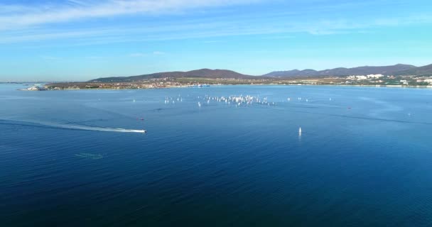 Régate à Gelendzhik Bay. Beaucoup de petits yachts d'une et deux personnes se bousculent dans la baie avec un vent léger. La vue depuis la hauteur du vol des oiseaux . — Video