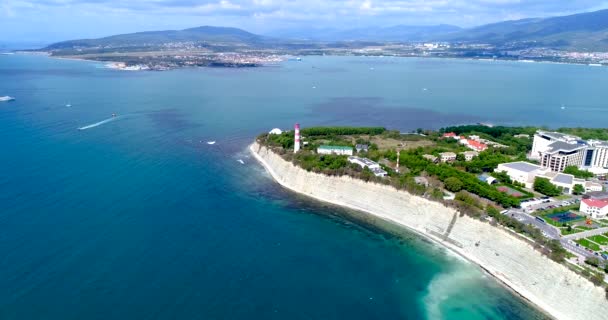 The Resort Of Gelendzhik. "Thick" Cape from a birds-eye view. Gelendzhik lighthouse, high cliff. Small waves in the sea. In the background, the city, Gelendzhik Bay, the Caucasus mountains. — Stock Video