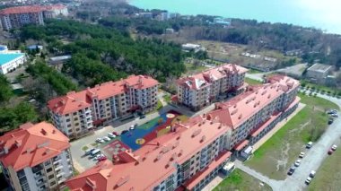 Yeni bina, dağların eteğindeki sahilde bulunan birkaç binadan oluşan çok katlı bir site. Gelendzhik Tatil Köyü. Kuşların yüksekliğinden en üst görünüm