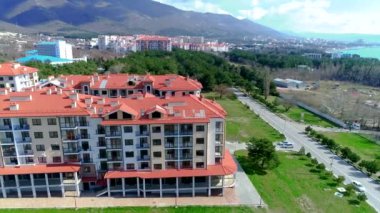Yeni bina. Çok katlı bir apartman. Yakın zamanda yaptırılmış. Dağ manzarası, deniz manzarası, otopark, çocuk parkı. Gelendzhik Oteli. Kırmızı bir binanın yakın çekimi.