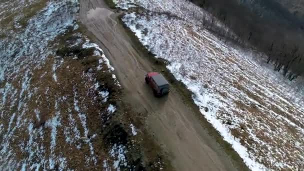 Позашляховик вирушає до руїн давньої фортеці в горах Кавказу взимку. Пташиний вид. Перехід до Ґеленджика — стокове відео