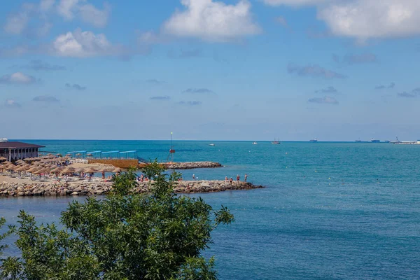 Gelendzhik resort-strand bij helder zonnig weer. Op de achtergrond, de stad Gelendzhik, de baai en de Kaukasus bergen — Stockfoto