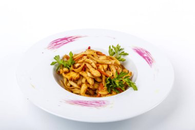 Udon Noodles, tavuk filetosu, kabak, kırmızı biber, havuç, susam. Beyaz arkaplan üzerine plaka.