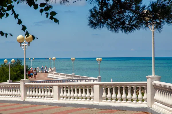 Svaha letoviska Gelendzhik za jasného slunečného počasí. Bílá balustráda a pouliční osvětlení. V pozadí Černého moře — Stock fotografie