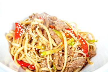 Tavuk ve mantarlı erişte, tavuk filetosu, kabak, kırmızı biber, susam, mantar. Beyaz arkaplan üzerine plaka