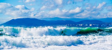 Karadeniz 'de fırtına ve fırtına. Tsemess Körfezi 'nin sularındaki kar beyazı denizden gelen zümrüt fırtınası dalgaları. Novorossiysk ve Kafkas dağları ufukta görünüyor.