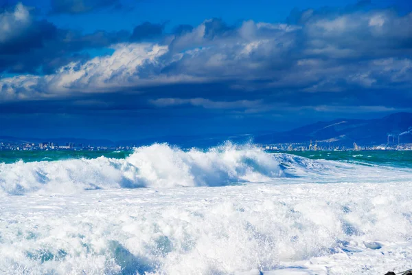 Karadeniz 'de fırtına ve fırtına. Tsemess Körfezi 'nin sularındaki kar beyazı denizden gelen zümrüt fırtınası dalgaları. Novorossiysk ve Kafkas dağları ufukta görünüyor.