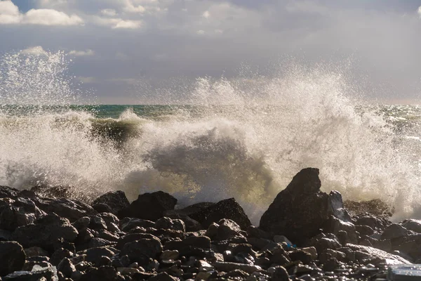 Gri fırtına dalgaları fırtına sırasında siyah kayalarda kırılır. Sprey, köpük. Karadeniz, Doob Burnu
