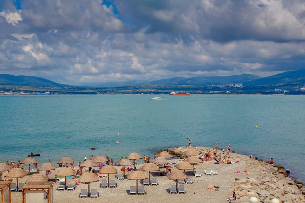 Курортный пляж Геленджик в ясную солнечную погоду. На заднем плане город Геленджик, Залив и Кавказские горы — стоковое фото